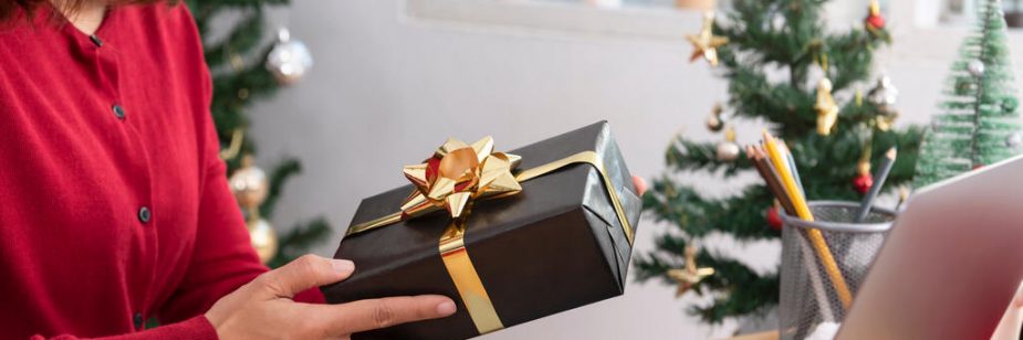 Mulher recebendo brindes gourmet em embalagem de presente