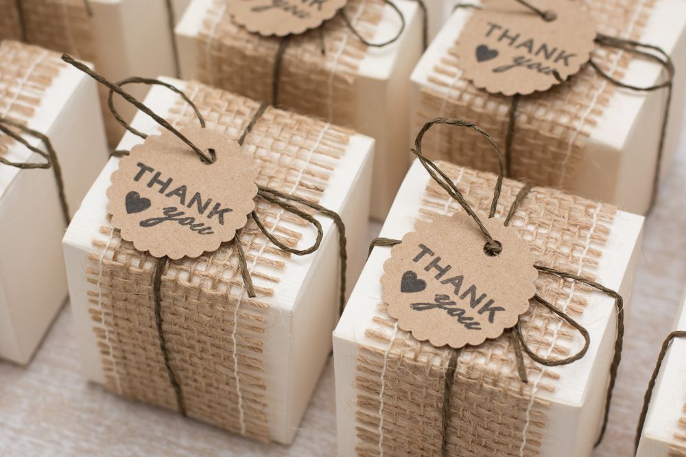 Lembrancinha de casamento rústica com caixinha branca, detalhe em juta, cordão de sisal e tag kraft personalizada escrita thank you.